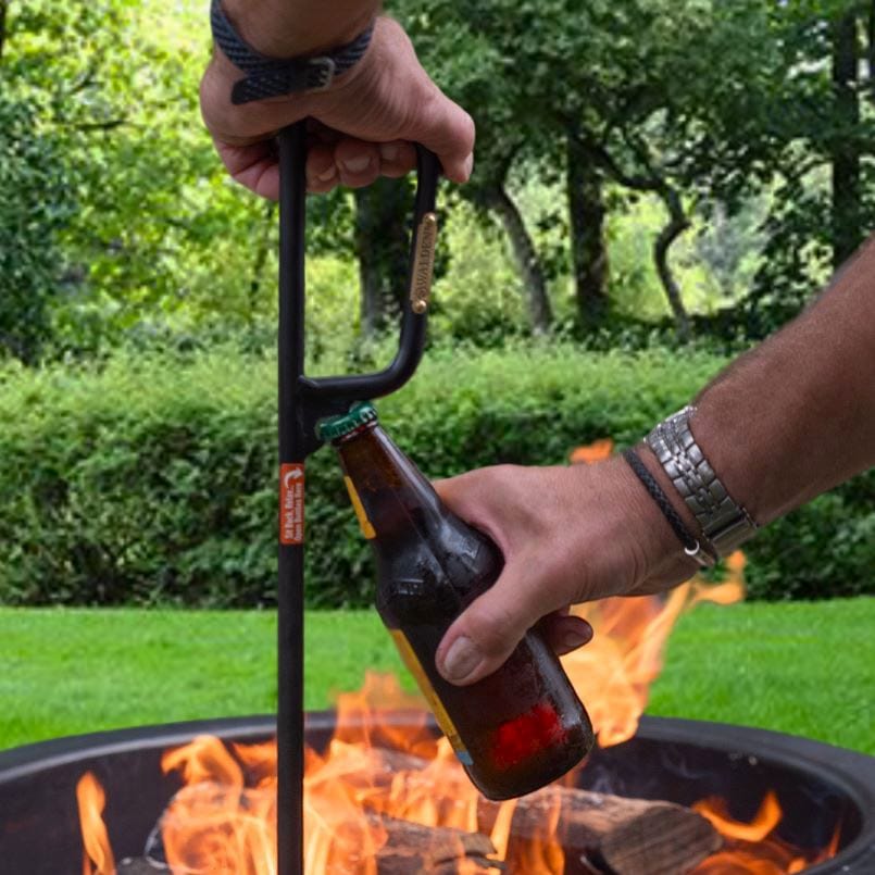 Man opening beer bottle with Walden Fire Poker which has a built-in bottle opener under handle