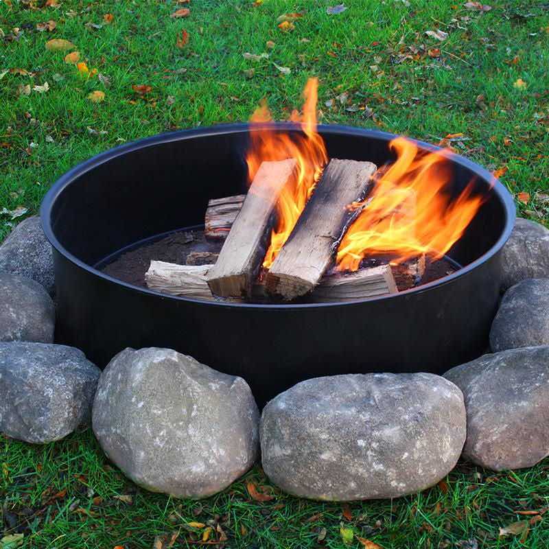 burning firewood contained within steel fire pit ring