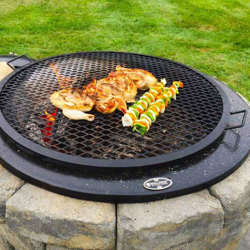 Chicken and kebabs roasting over seasoned grilling grate.