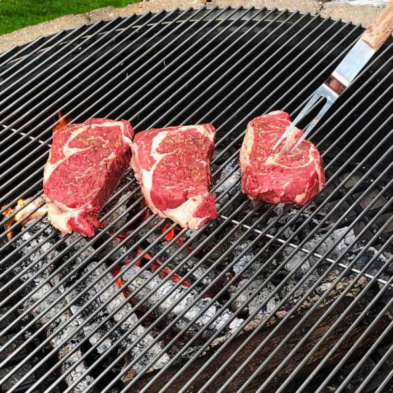 Grill steaks over the fire.