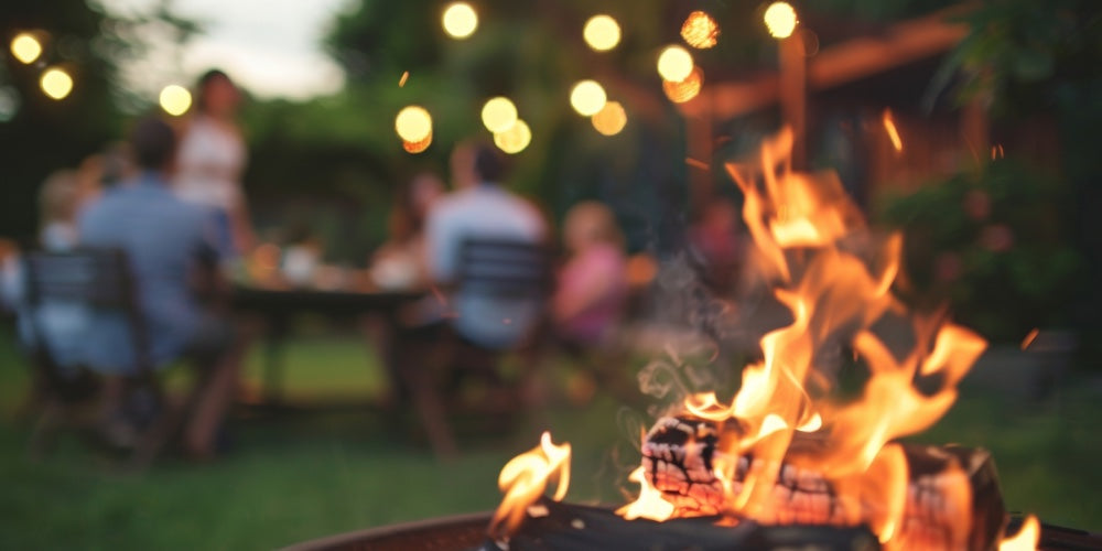 Fire burning with people gathered in the background having a party