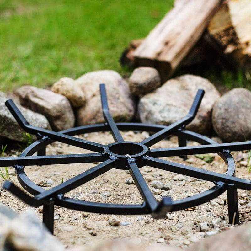 powder coated wagon wheel grate sitting on prepared ground to elevate firewood