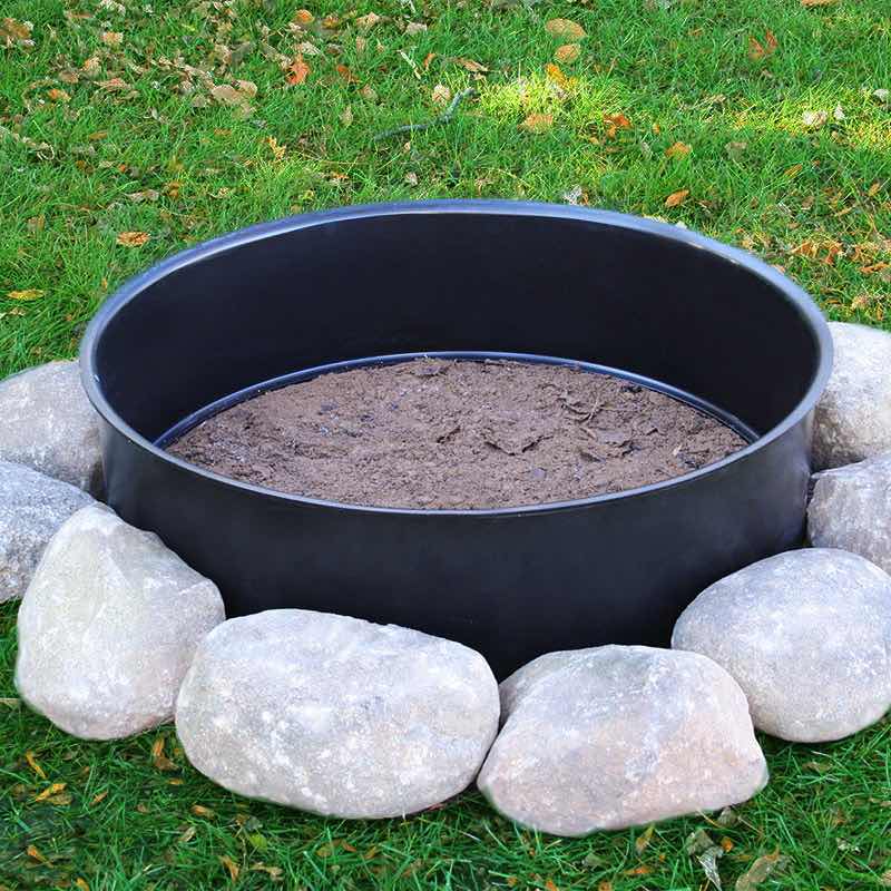 Steel Fire Ring on prepared ground surrounded by decorative boulders to create a stand alone fire pit