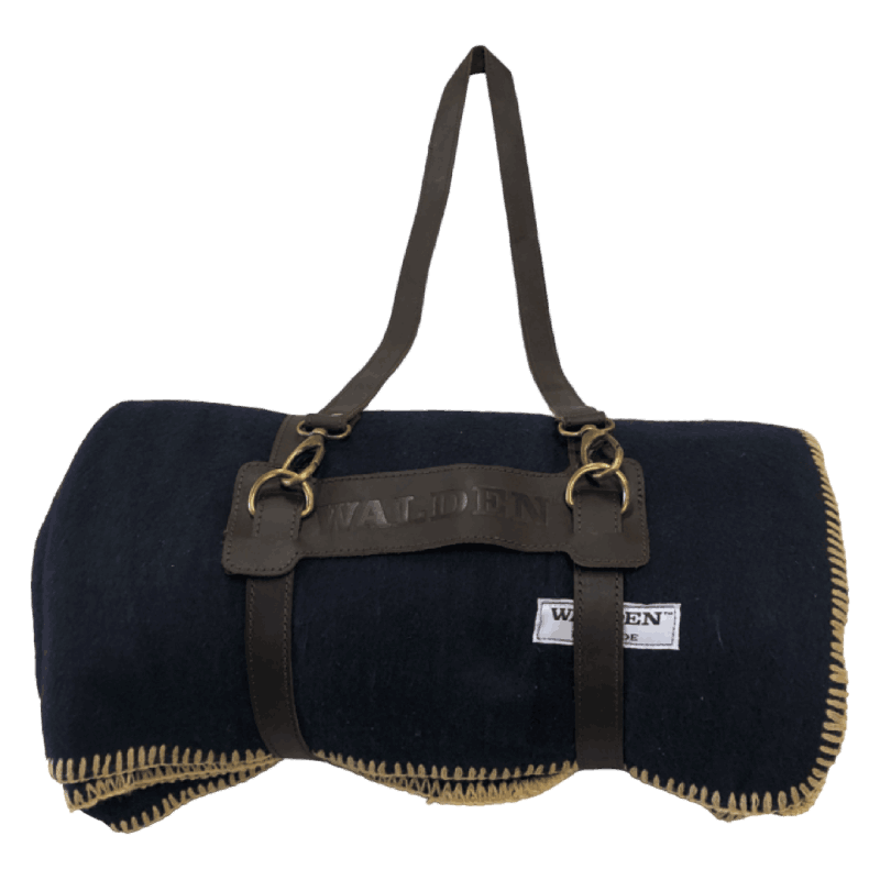 Warm heavy-duty Walden blanket in midnight blue suspended by a brown leather strap.